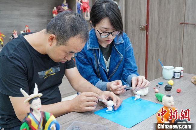 <a target='_blank'  data-cke-saved- >中新社</a>記者(右)現(xiàn)場(chǎng)體驗(yàn)面塑制作過(guò)程?！￡悹?zhēng)強(qiáng) 攝