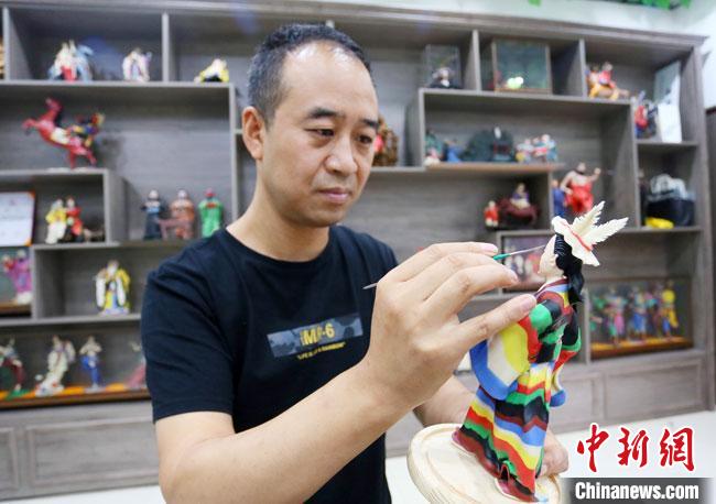 圖為安秋平正在創(chuàng)作代表隴南文縣民俗的《白馬人》作品?！「哒?攝