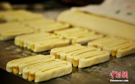 圖為面劑被涂上胡麻油，切成條狀用作月餅的花型制作。張文 攝