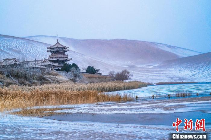 2021年11月28日，雪落鳴沙山月牙泉景區(qū)?！⊥醣筱y 攝