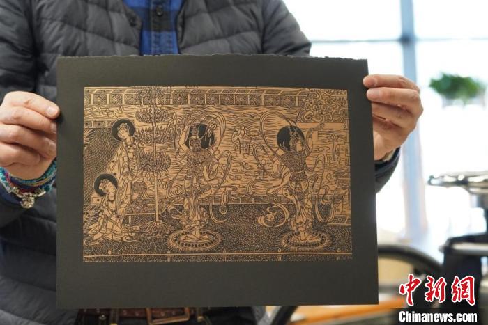 圖為手工書藝人展示敦煌雕版壁畫印刷品?！【琶赖┰?　攝