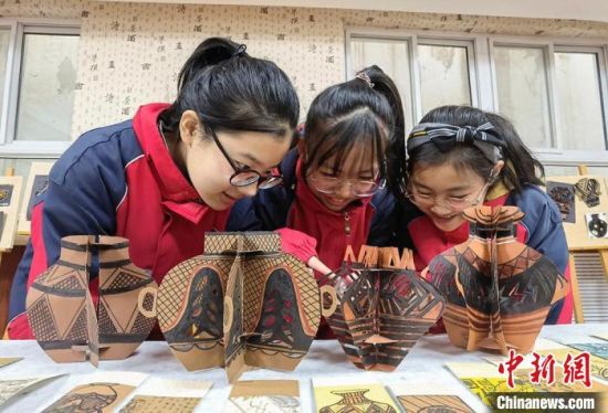 圖為學(xué)生用紙創(chuàng)作的立體彩陶?！⒂裉?攝