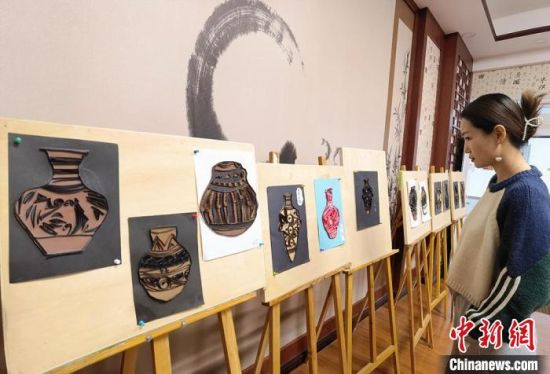 圖為學(xué)生用衍紙材料制作的彩陶紋飾?！⒂裉?攝