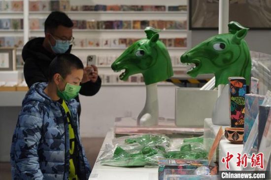 圖為“神馬來了”銅奔馬頭套吸引參觀者駐足?！【琶赖┰?攝