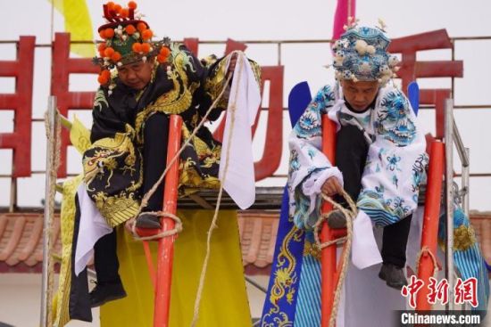 圖為“苦水高高蹺”表演者通過麻繩將腳固定在腳踏板，并在腿部纏繞六七圈?！【琶赖┰?攝