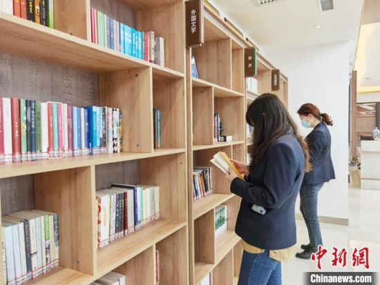 圖為在甘肅公航旅建設(shè)集團(tuán)有限公司的職工書屋，職工挑選書籍?！⌒煅?攝