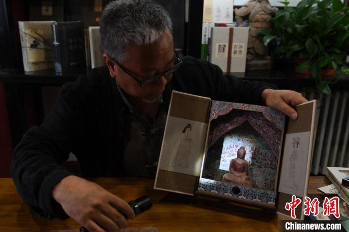 圖為讀者出版集團讀者晉林工作室獨立出品人徐晉林，展示互動性強的敦煌題材手工書。(資料圖) 楊艷敏 攝