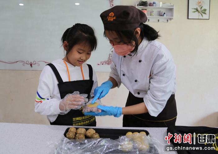 圖為在甘臺(tái)胞小朋友在工作人員指導(dǎo)下制作月餅。九美旦增 攝