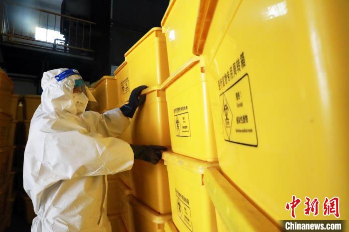 圖為工作人員搬運醫(yī)療廢物專用周轉(zhuǎn)箱?！∥航ㄜ?攝