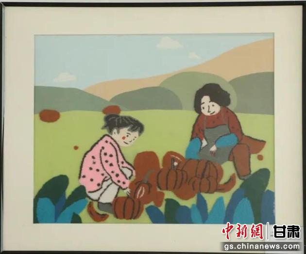 嘉峪關(guān)市新城鎮(zhèn)新城村農(nóng)業(yè)產(chǎn)業(yè)園區(qū)內(nèi)，母女兩人在摘南瓜。刺繡 馬艾米乃 繡稿 敬紅霞