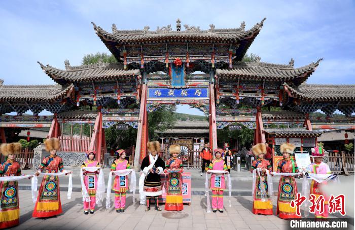 圖為身穿土族服飾的工作人員迎接訪客?！⊙Φ?攝