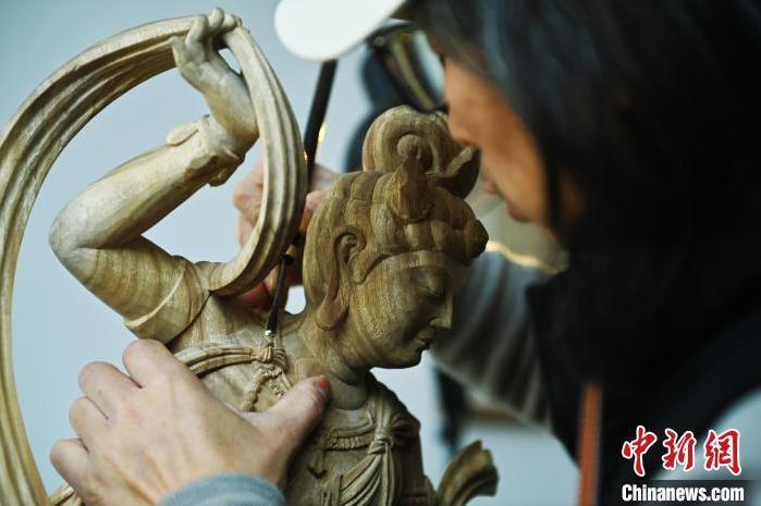 圖為季茂杰進行敦煌元素的木雕創(chuàng)作。李亞龍 攝</p>
<p>