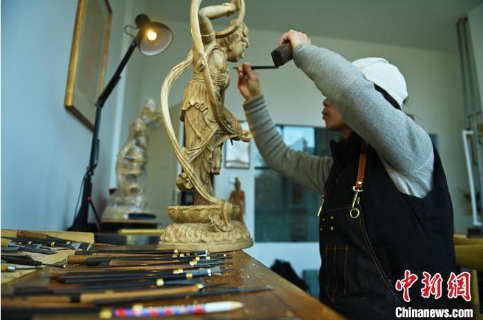 圖為季茂杰進行敦煌元素的木雕創(chuàng)作。李亞龍 攝</p>
<p>