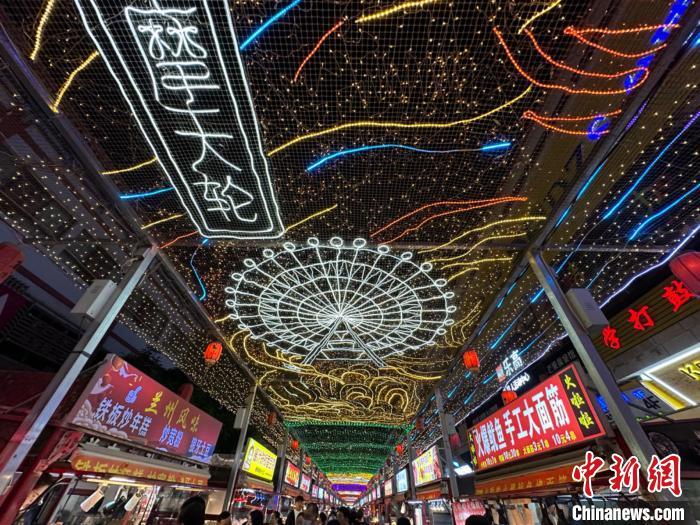 圖為明清街夜市燈光點(diǎn)亮具有武威文化元素的“摩天輪”彩燈。　戴文昌 攝</p><p>