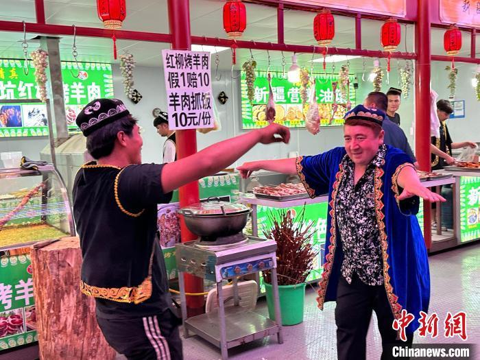 圖為餐飲經(jīng)營(yíng)者在“西涼不夜城”跳起舞蹈引客。　戴文昌 攝</p><p>