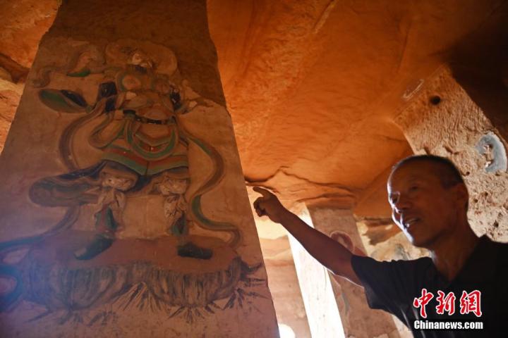 7月15日，甘肅省平?jīng)鍪袥艽h百里石窟長廊羅漢洞石窟內(nèi)，該窟文保員郭建平介紹窟內(nèi)石刻彩繪壁畫。郭建平家中三代人曾自發(fā)保護(hù)羅漢洞石窟。羅漢洞石窟遺存40余個窟龕，以北魏至清代風(fēng)格為主。中新社記者 李亞龍 攝</p>
<p>