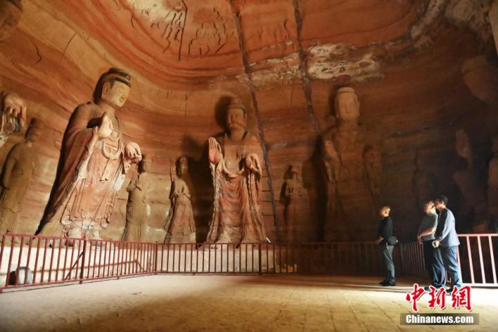 7月15日，游人參觀甘肅省平?jīng)鍪袥艽h百里石窟長廊中的南石窟寺1號窟。百里石窟長廊位于涇川縣境內(nèi)，由512個石窟、5眼窟中石井組成，現(xiàn)存王母宮石窟、鳳凰山石窟、南石窟寺、丈八寺石窟、羅漢洞石窟、太山寺石窟等規(guī)模較大的石窟群，還有數(shù)量眾多的小石窟群。南石窟寺開鑿于北魏永平三年，其中1號窟屬于大型七佛窟，七佛高達(dá)6米。中新社記者 李亞龍 攝