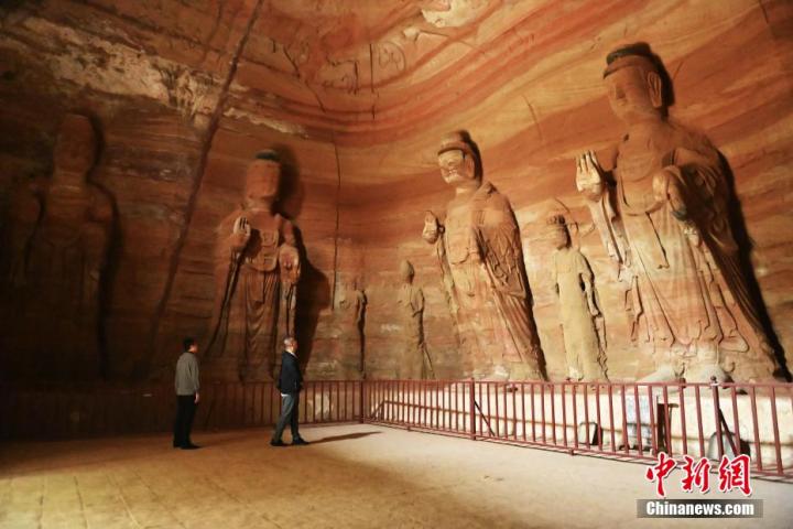 7月15日，游人參觀甘肅省平?jīng)鍪袥艽h百里石窟長廊中的南石窟寺1號窟。百里石窟長廊位于涇川縣境內(nèi)，由512個石窟、5眼窟中石井組成，現(xiàn)存王母宮石窟、鳳凰山石窟、南石窟寺、丈八寺石窟、羅漢洞石窟、太山寺石窟等規(guī)模較大的石窟群，還有數(shù)量眾多的小石窟群。南石窟寺開鑿于北魏永平三年，其中1號窟屬于大型七佛窟，七佛高達(dá)6米。中新社記者 李亞龍 攝