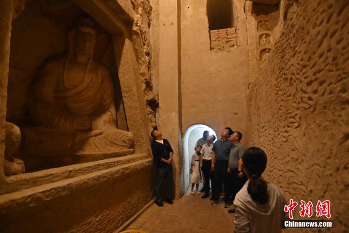 7月15日，游人參觀甘肅省平?jīng)鍪袥艽h百里石窟長廊中的王母宮石窟。百里石窟長廊位于涇川縣境內(nèi)，由512個石窟、5眼窟中石井組成，現(xiàn)存王母宮石窟、鳳凰山石窟、南石窟寺、丈八寺石窟、羅漢洞石窟、太山寺石窟等規(guī)模較大的石窟群，還有數(shù)量眾多的小石窟群。王母宮石窟又名千佛洞，該窟設(shè)計宏大，造像生動，窟內(nèi)擁有造像數(shù)百尊，是較為珍貴的佛教文化歷史遺存。中新社記者 李亞龍 攝</p>
<p>