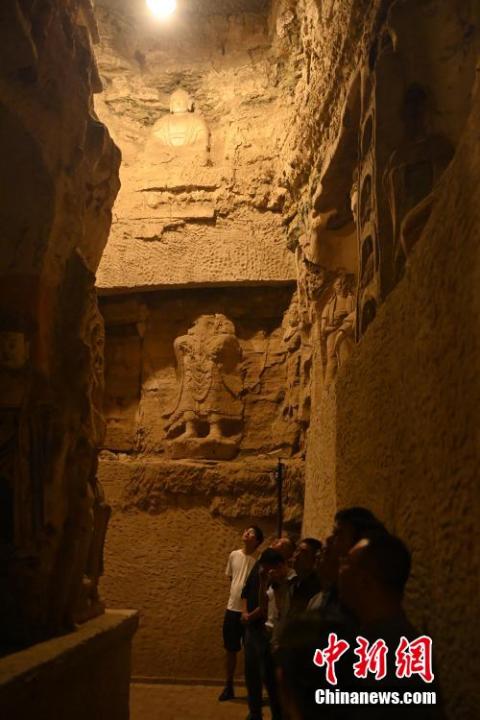 7月15日，游人參觀甘肅省平?jīng)鍪袥艽h百里石窟長廊中的王母宮石窟。百里石窟長廊位于涇川縣境內(nèi)，由512個石窟、5眼窟中石井組成，現(xiàn)存王母宮石窟、鳳凰山石窟、南石窟寺、丈八寺石窟、羅漢洞石窟、太山寺石窟等規(guī)模較大的石窟群，還有數(shù)量眾多的小石窟群。王母宮石窟又名千佛洞，該窟設(shè)計宏大，造像生動，窟內(nèi)擁有造像數(shù)百尊，是較為珍貴的佛教文化遺存。中新社記者 李亞龍 攝</p>
<p>