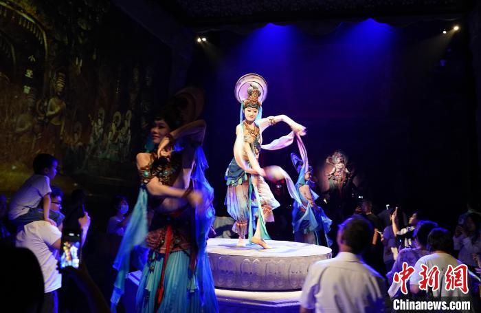 《樂動(dòng)敦煌》是全球首部洞窟式沉浸體驗(yàn)劇，利用真人與數(shù)字影像虛實(shí)交換實(shí)現(xiàn)沉浸式體驗(yàn)。圖為2023年8月28日晚，《樂動(dòng)敦煌》演出。(資料圖)中新社記者 毛建軍 攝